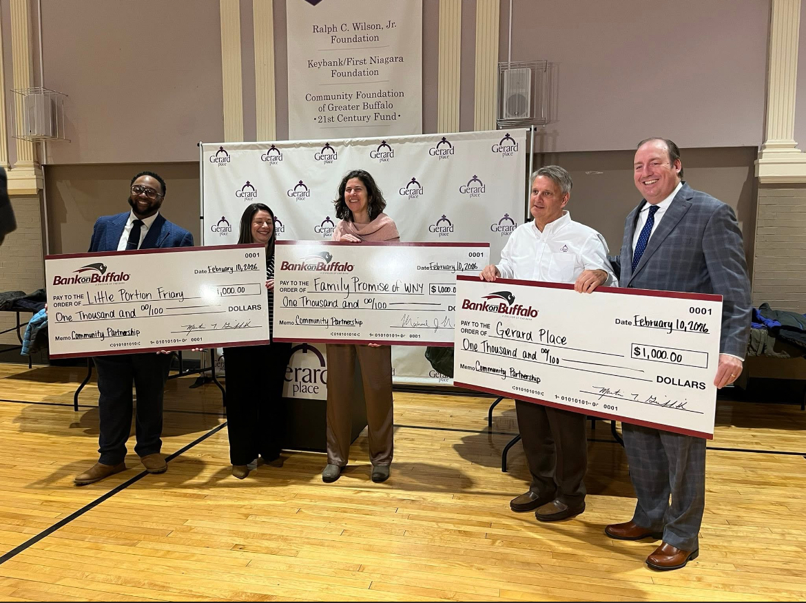 workers posed with checks donated by the BankOnBuffalo crew.