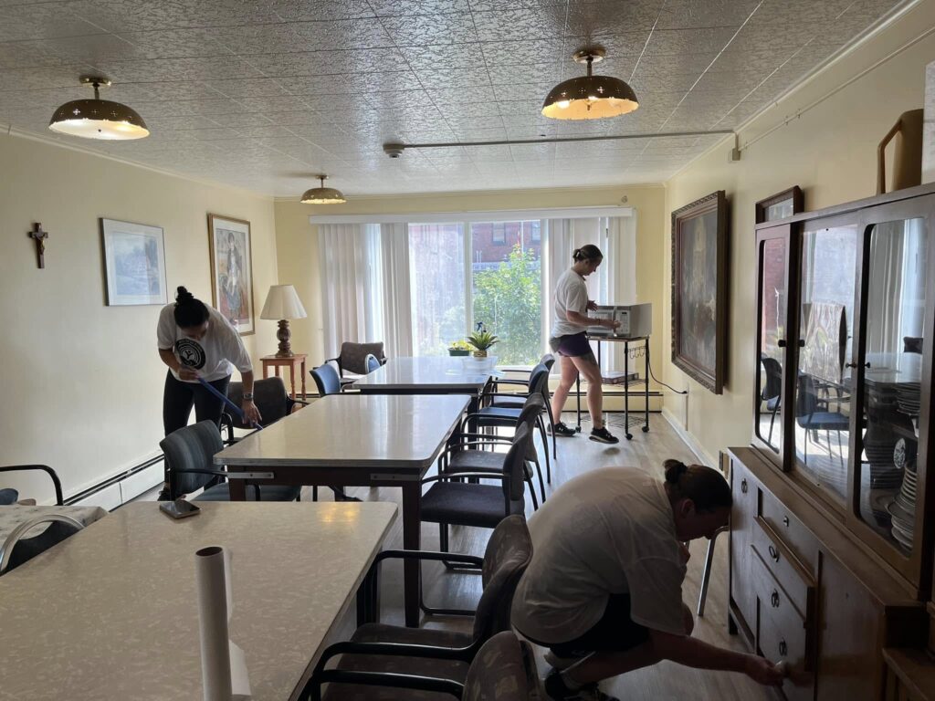 a group of volunteers cleaning up the common areas of the Little Portion Friary.